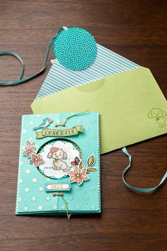 a card with a teddy bear on it next to some envelopes and a string