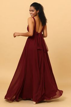 a woman in a long red dress with her back turned to the camera and she is wearing