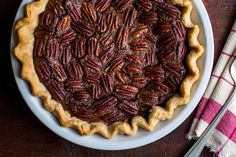 a pecan pie on a wooden table with a fork and napkin next to it