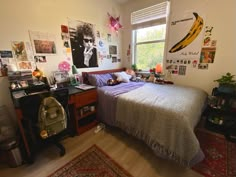 a bed room with a neatly made bed and lots of pictures on the wall above it