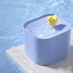 a yellow rubber duck sitting on top of a blue box