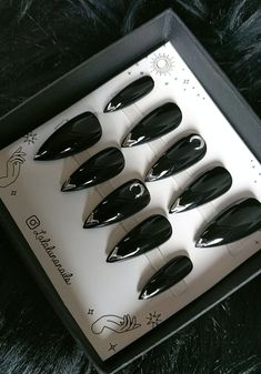 six fake black nails are in a box