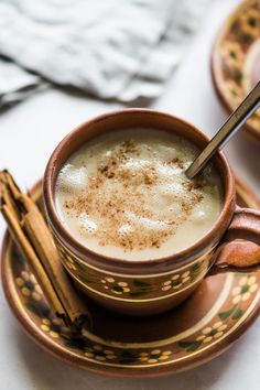 there is a cup of coffee with cinnamon on the saucer