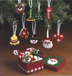 christmas ornaments hanging from a tree on a wooden table in front of a small box