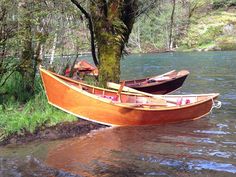 two wooden boats tied to a tree in the water