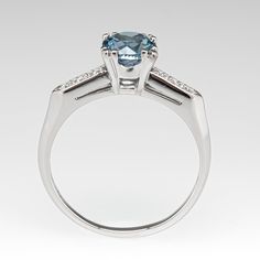 This stunning light icy teal sapphire engagement ring is centered with a round brilliant cut no heat Montana sapphire that we sourced and set in a vintage platinum diamond mounting. The shoulders are each bead set with three (3) round brilliant cut diamonds. The ring measures 7.3mm at the top, rises 7.3mm above the finger, tapering to 1.5mm wide and 1.2mm thick at the base of the shank. The ring is currently a size 9 and we offer complimentary sizing to fit. Aquamarine Brilliant Cut Diamond Ring For Formal Occasions, Formal Aquamarine Diamond Ring With Brilliant Cut, Elegant Asscher Cut Topaz Ring With Center Stone, Classic Diamond Topaz Promise Ring, Classic Topaz Promise Ring With Diamond Accents, Classic Round Cut Blue Topaz Birthstone Ring, Formal Aquamarine Diamond Ring With Prong Setting, Classic Topaz Ring With Diamond For Promise, Classic Birthstone Ring With Round Cut Blue Topaz