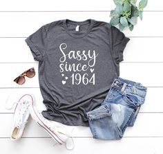 a t - shirt that says sassy since 1994 next to some jeans and sunglasses