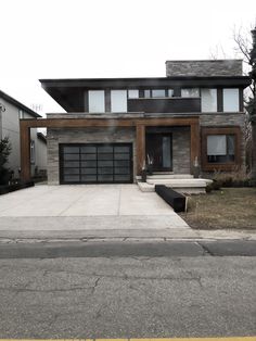 a modern house with two car garages on the street