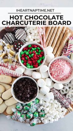 a platter filled with hot chocolate and marshmallows, pretzels, crackers, candy canes