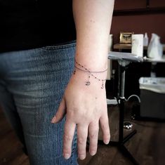 a woman's hand with a tiny bracelet on it