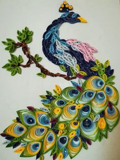 an intricately painted peacock sitting on top of a tree branch