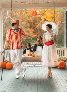 a man and woman dressed up in halloween costumes on a porch with pumpkins around them