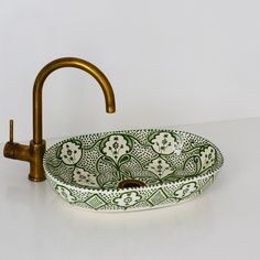 a green and white sink sitting on top of a counter next to a faucet