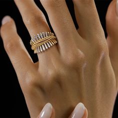 a woman's hand wearing a gold ring with three rows of diamonds on it