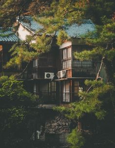 an old house is surrounded by trees and rocks