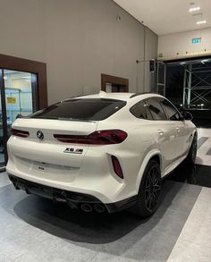 a white car is parked in a showroom