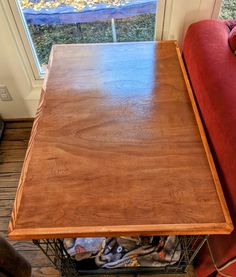 a wooden table sitting next to a red couch