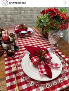 a red and white checkered table setting with napkins, silverware and christmas decorations