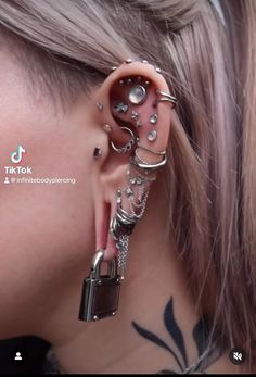 a woman with piercings on her ear and behind the ear is a padlock