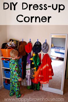 a young boy standing in front of a closet filled with clothes