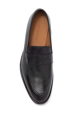 A sleek slip-on silhouette adds a minimalist style to this smooth leather loafer topped with a penny strap vamp detail that offers a vintage charm. Almond toe Slip-on style Leather upper, textile lining, leather sole Imported Classic Wingtip Slip-ons For Work, Classic Business Slip-ons With Plain Toe, Classic Slip-ons With Leather Footbed For Business Casual, Classic Slip-on Dress Shoes With Almond Toe, Classic Slip-ons With Leather Footbed And Pointed Toe, Classic Slip-ons With Pointed Toe And Leather Lining, Classic Loafers With Rubber Sole And Pointed Toe, Classic Pointed Toe Moccasins With Branded Insole, Classic Slip-ons With Pointed Toe And Removable Insole