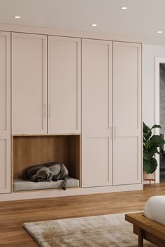 a dog is sleeping in its bed under the cabinet doors on this room's wall