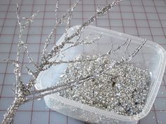 a plastic container filled with silver glitter branches