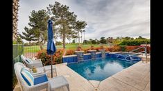 an outdoor swimming pool with lounge chairs and umbrellas