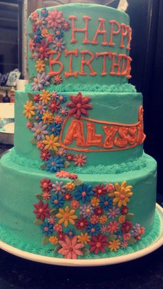 a birthday cake with flowers and the words happy birthday aless on it's side