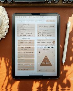 a tablet sitting on top of a table next to a cup of coffee and a pen