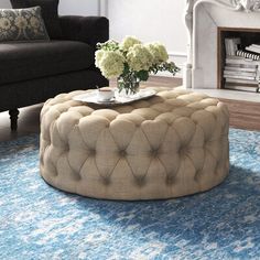 a living room filled with furniture and a blue rug on the floor in front of a fire place