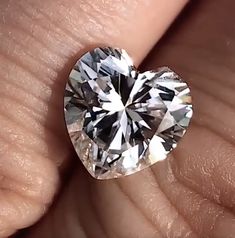 a heart shaped diamond being held in someone's hand