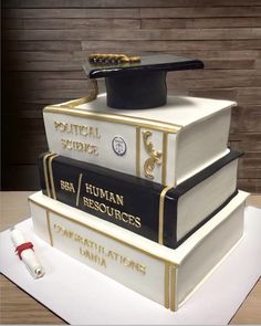 a cake made to look like books stacked on top of each other with graduation caps and tassels