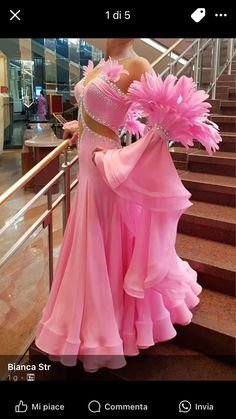 a woman in a pink dress standing on some stairs