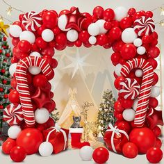 a christmas scene with red and white balloons in the shape of a candy cane arch