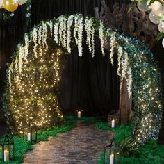 a wedding arch decorated with lights and greenery