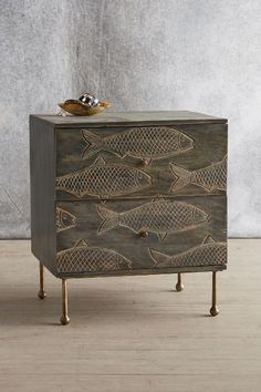 a wooden cabinet with fish carvings on it