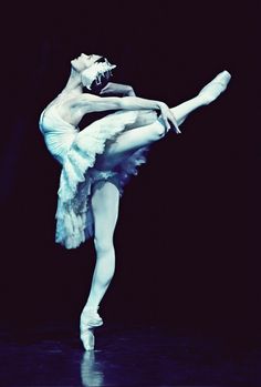 a ballerina in white tutu and leotard with one leg bent forward