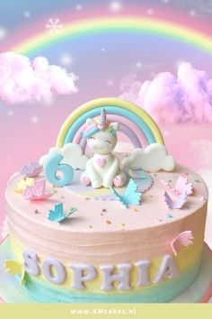 there is a birthday cake with a unicorn on top and rainbows in the background