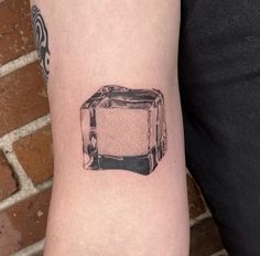 a black and white photo of a toaster tattoo on the arm