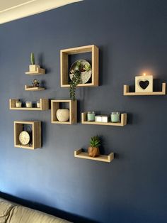 several wooden shelves are arranged on the wall above a couch in a room with blue walls