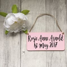 a pink sign that says, rose ame arvold is my 2017 on it next to a white flower