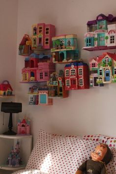 there is a doll house on the wall next to a bed with polka dot sheets