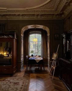 a dining room with a table and chairs in front of a large window that looks out onto the woods