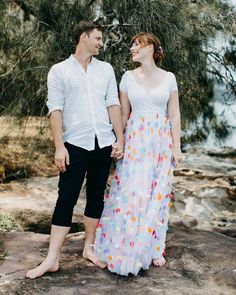 a man and woman standing next to each other holding hands