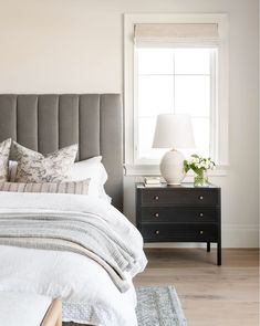 a bedroom with a bed, nightstand and window