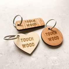 three wooden keychains with the words touch wood and touch wood engraved on them