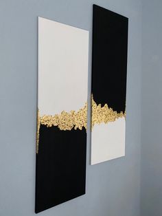 two black and white paintings on the wall with gold trimmings in an office setting