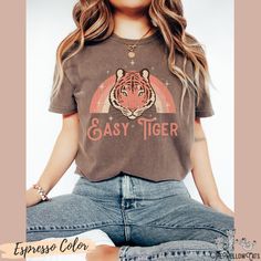 Cute retro Easy Tiger tee The Easy Tiger Comfort colors graphic shirt, a fully customizable tee made 100% with ring-spun cotton. The soft-washed, garment-dyed fabric brings extra coziness to your wardrobe while the relaxed fit makes it an excellent daily choice. The double-needle stitching throughout the tee makes it highly durable while the lack of side-seams helps the shirt retain its tubular shape. .: 100% ring-spun cotton .: Medium fabric (6.1 oz/yd² (206.8 g/m .: Relaxed fit .: Sewn-in twil Retro T-shirt For Everyday Fall Wear, Vintage Slogan T-shirt For Fall, Everyday Retro T-shirt With Funny Print, Retro Slogan T-shirt For Fall, Retro Everyday T-shirt For Fall, Vintage Tiger, Tiger Graphic, Tshirt Oversized, Easy Tiger