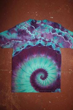 a purple and blue tie - dyed shirt on a brown background